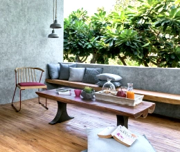 A terrace with a wooden bench and concrete walls. Exterior painters by Asian Paints.