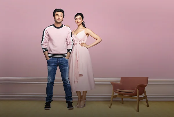 Ranbir Kapoor and Deepika Padukone in front of a Pink Wall. Know More about Royal Health Shield Anti Bacterial Paint.