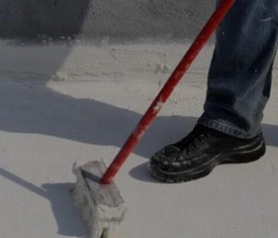 An Image of Worker Painting the Roof White With a Broom with a Red Handle. Blog on "How Roof Proofing Helps in Cooling the Home"